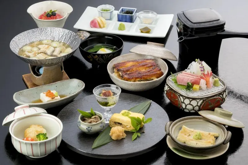 Table dressée avec une variété de plats japonais traditionnels.