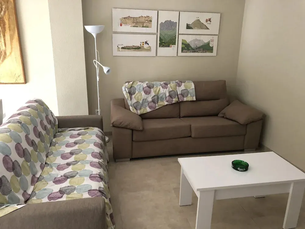 Espace de détente intérieur avec canapés et lampadaire.