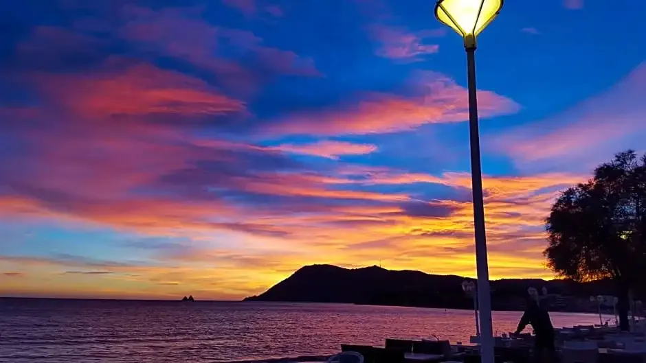 Un ciel coloré au coucher du soleil surplombe la mer et une plage.