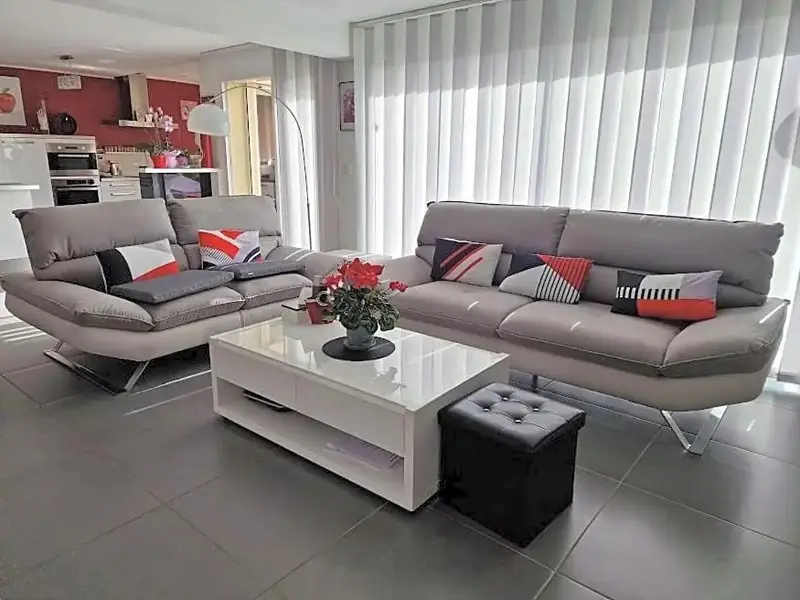 Un salon moderne avec un grand canapé d'angle et une table basse.