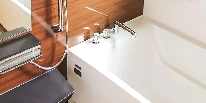 Une baignoire blanche moderne avec robinetterie chromée et fond en bois.