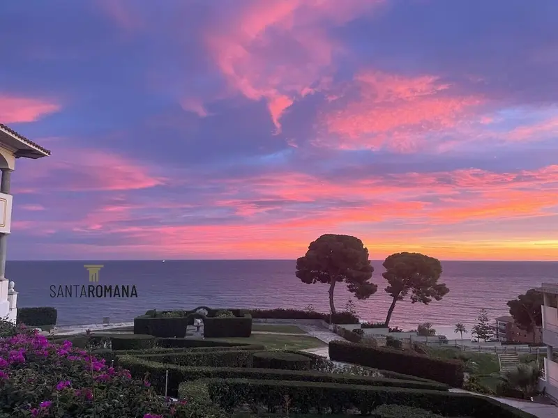 Ciel rose et orangé au coucher du soleil sur la mer.