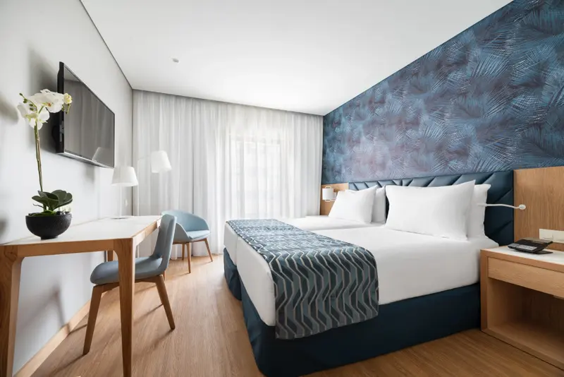 Une chambre lumineuse avec un grand lit et un espace bureau.