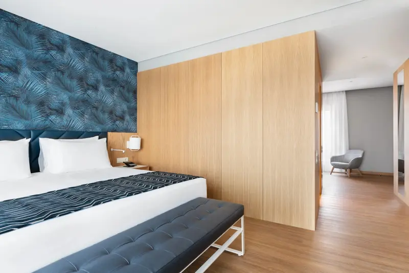 Une chambre lumineuse avec un grand lit et un espace détente.