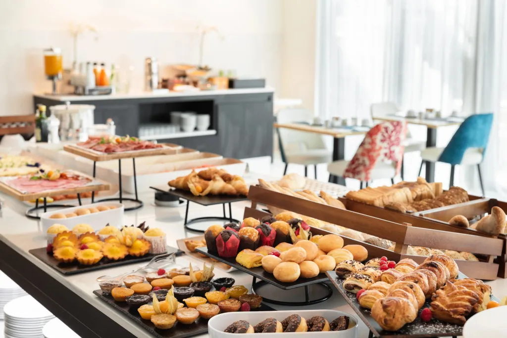 Un buffet propose une variété de viennoiseries et de charcuteries.