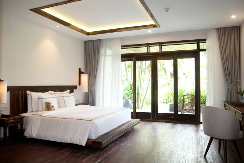 Une chambre lumineuse avec un grand lit et un accès à une terrasse.