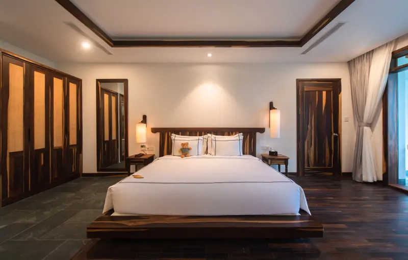 Une chambre lumineuse avec un grand lit et des meubles en bois.