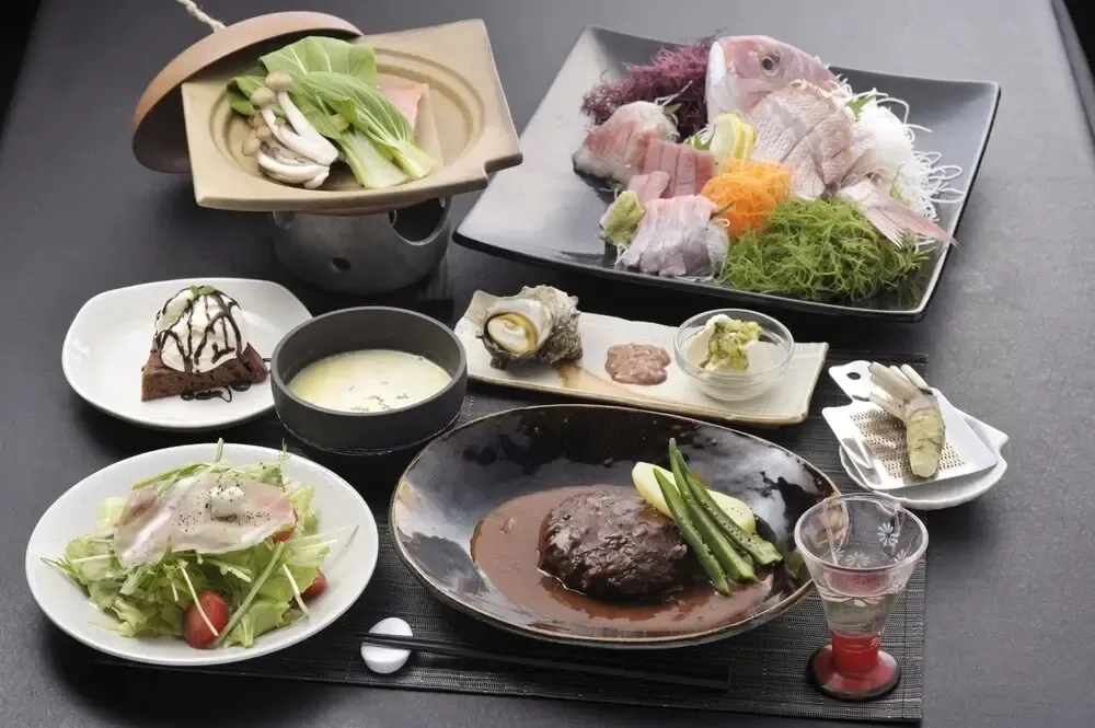 Une table est dressée avec plusieurs plats raffinés et colorés.