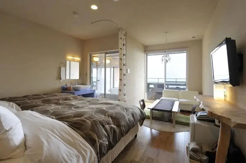 Une chambre lumineuse avec un grand lit et un accès à une terrasse.