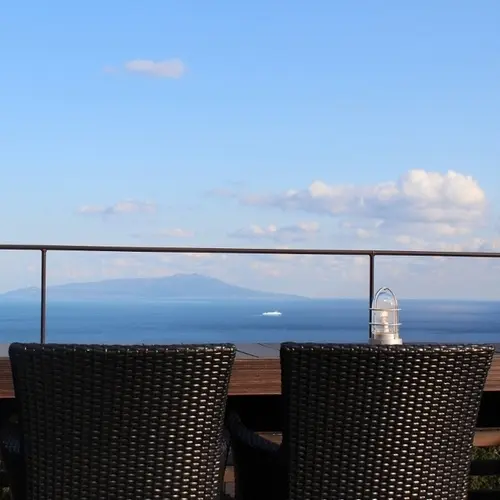 Vue sur la mer depuis une terrasse avec une table et des chaises.