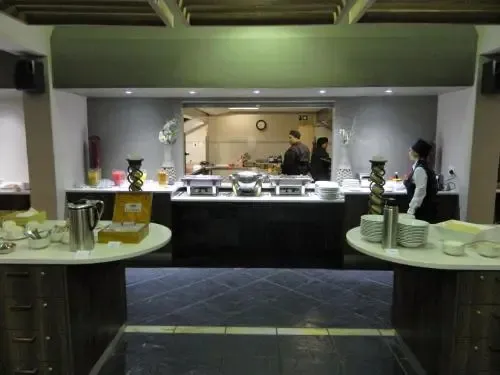 Un buffet propose une variété de plats et de boissons dans une salle lumineuse.