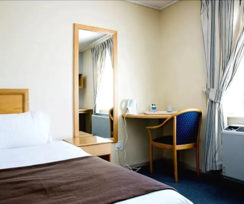 Une chambre lumineuse avec un lit et un espace bureau.