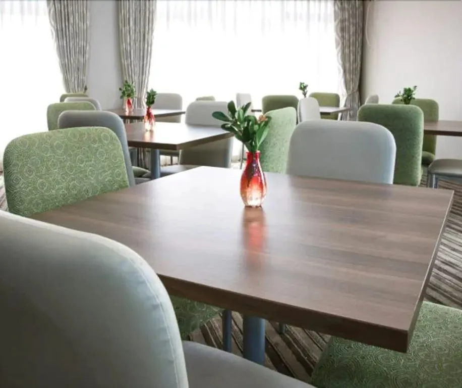 Une salle lumineuse avec des tables et des chaises confortables.