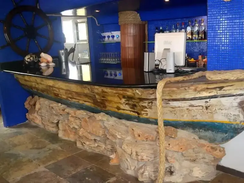 Un comptoir de bar original est aménagé dans la coque d'un bateau en bois.