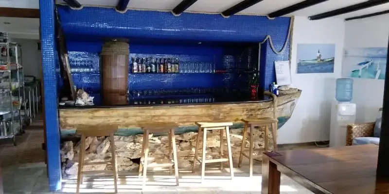 Un comptoir de bar en bois brut est présenté dans une pièce lumineuse.