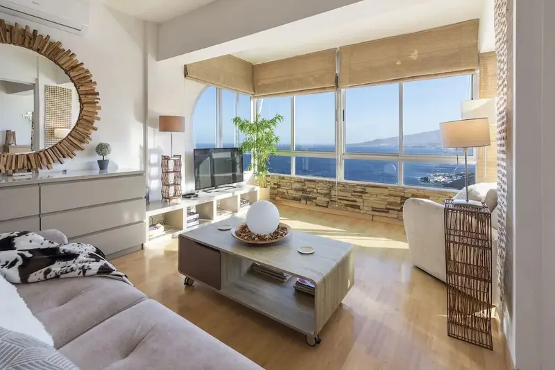 Un salon lumineux offre une vue dégagée sur la mer.