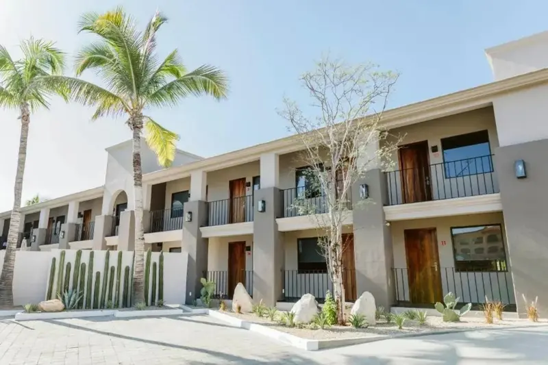 Façade d'un bâtiment avec des balcons et une végétation tropicale.