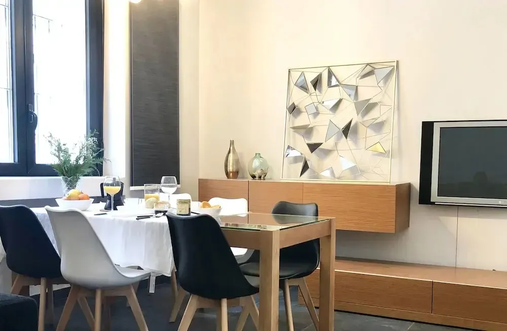 Une table est dressée pour le repas dans une pièce lumineuse.