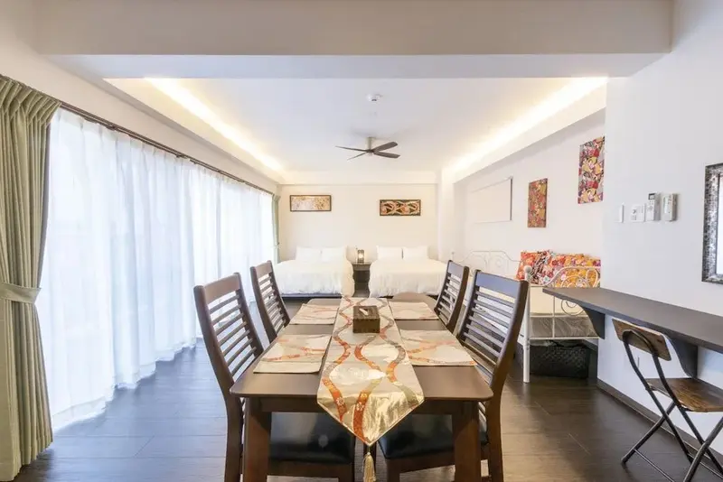 Une salle à manger lumineuse avec une table en bois et des chaises.