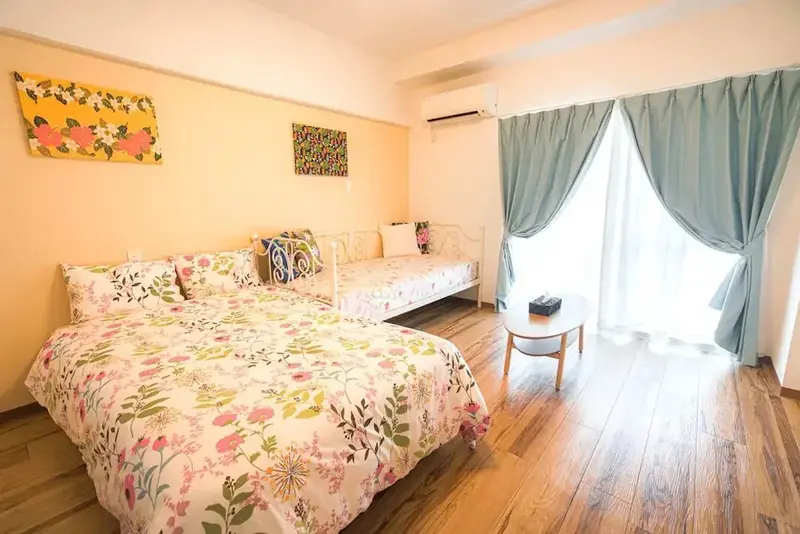 Une chambre lumineuse avec deux lits décorés de motifs floraux.