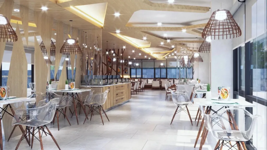 Une salle lumineuse avec des tables et des chaises transparentes est prête pour le service.