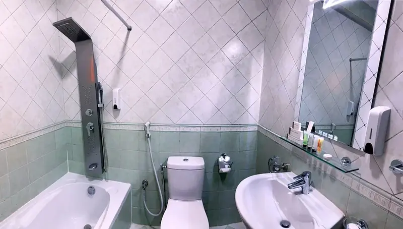 Une salle de bain lumineuse avec baignoire, douche et deux lavabos.