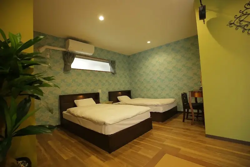 Une chambre lumineuse avec deux lits simples et un décor coloré.
