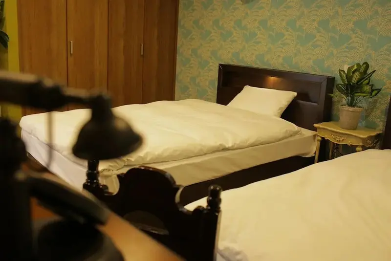 Une chambre avec deux lits simples et une décoration florale.