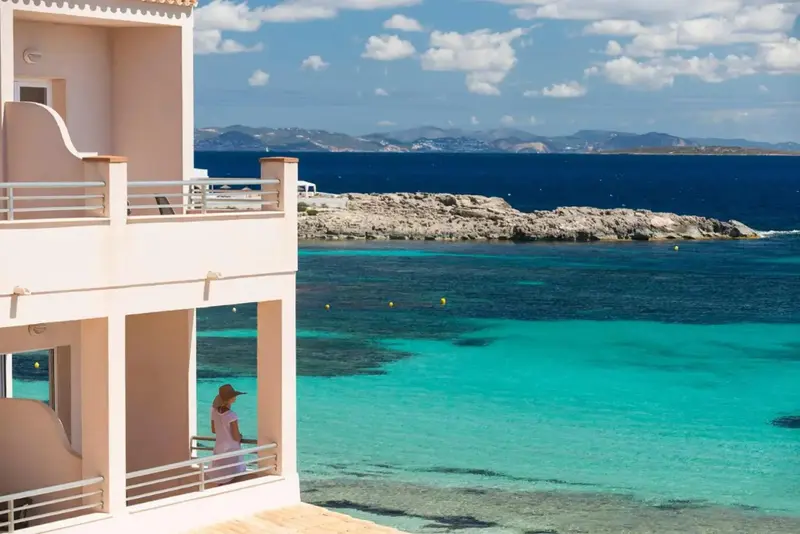 Vue sur la mer turquoise depuis une terrasse d'habitation.