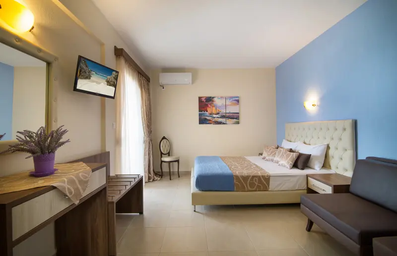 Une chambre lumineuse avec un lit double et un coin salon.