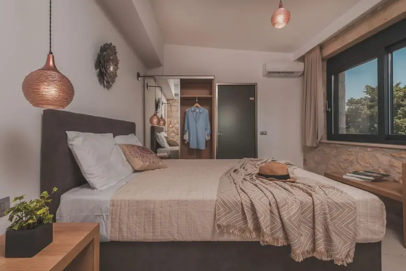 Une chambre à coucher lumineuse avec un grand lit et une décoration sobre.