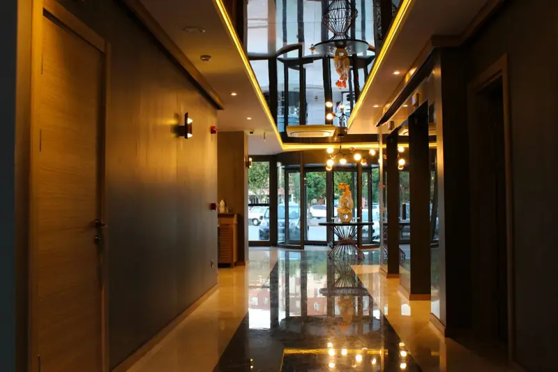 Un couloir lumineux mène vers l'entrée d'un bâtiment moderne.