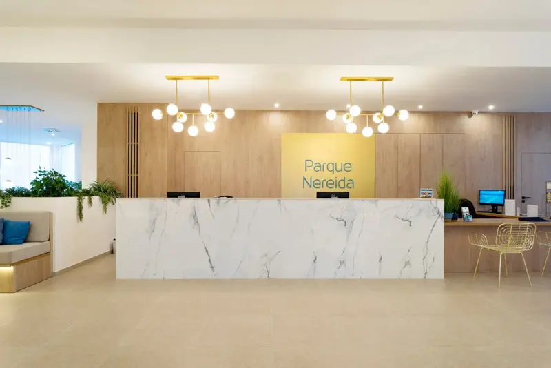 Un comptoir d'accueil moderne avec un mur en bois et un éclairage suspendu.