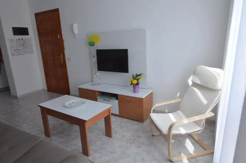 Une pièce lumineuse avec un canapé, une table basse et un meuble télévision.