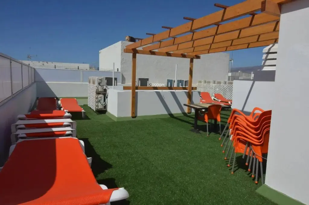 Espace extérieur aménagé avec des transats et des tables.