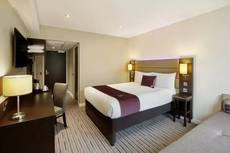 Une chambre d'hôtel lumineuse avec un grand lit et un bureau.