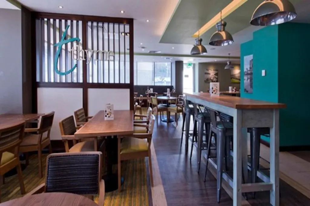 Une salle lumineuse avec des tables et un comptoir de bar.