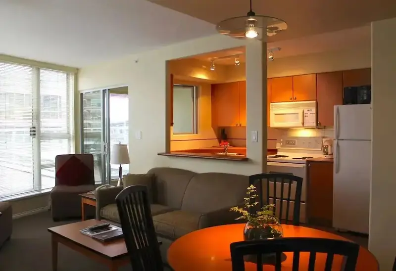 Espace de vie lumineux avec coin salon et cuisine ouverte.