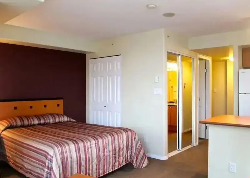 Une chambre avec un lit et un espace cuisine.