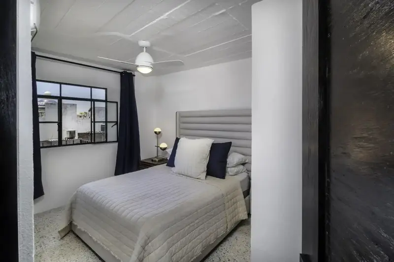 Une chambre lumineuse avec un lit double et une fenêtre.