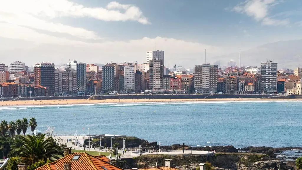 Vue d'une ville côtière avec une plage et des bâtiments alignés.