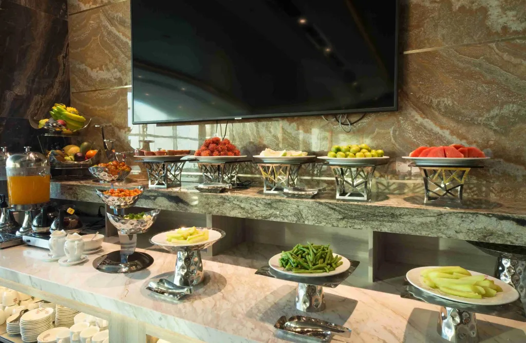 Un buffet propose une variété de fruits frais et de jus d'orange.