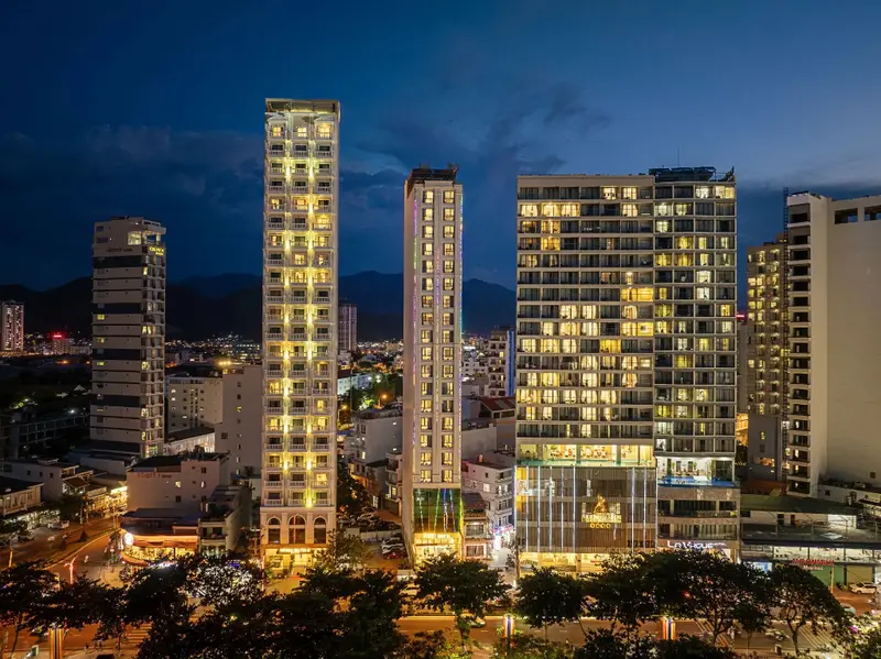 Vue nocturne sur des immeubles illuminés dans une ville côtière.