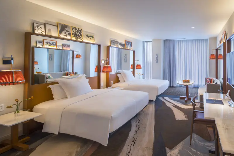 Une chambre lumineuse avec deux lits simples et une décoration moderne.