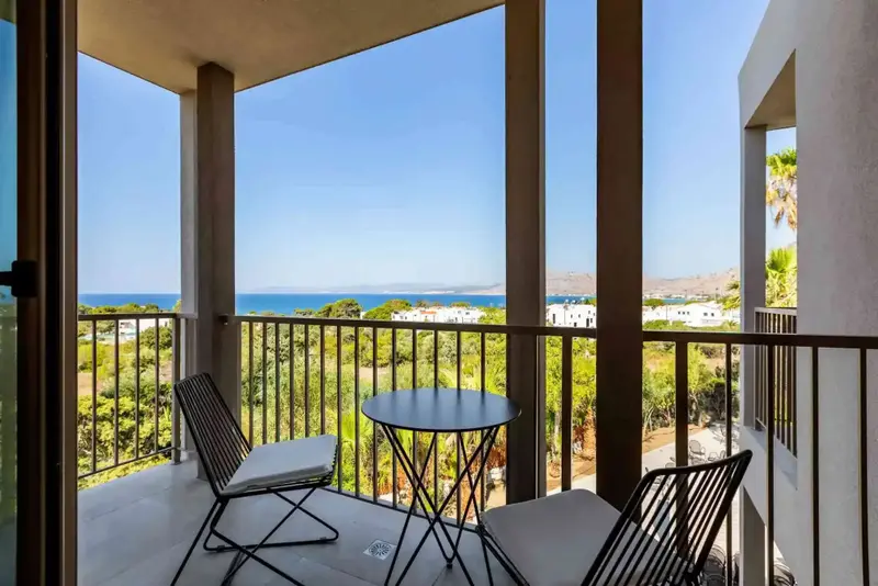 Terrasse avec mobilier d'extérieur donnant sur une vue mer et un paysage montagneux.