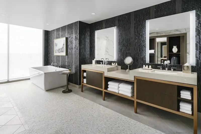Une salle de bain spacieuse avec baignoire et deux vasques.