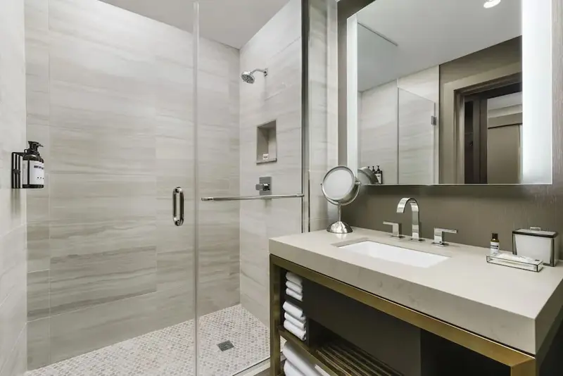 Une salle de bain moderne avec douche à l'italienne et grand miroir.