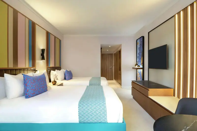 Chambre lumineuse avec deux lits simples et une décoration moderne.