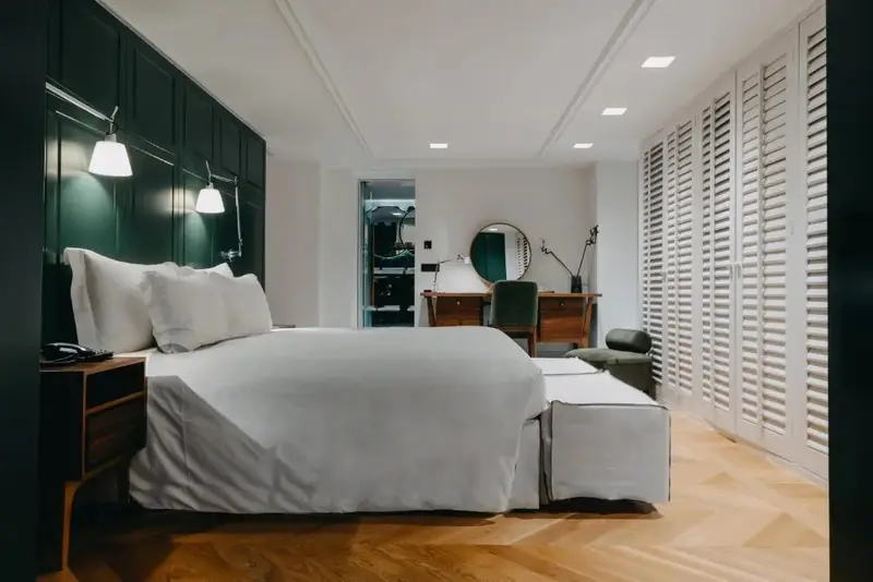 Une chambre lumineuse avec un grand lit recouvert de draps blancs.