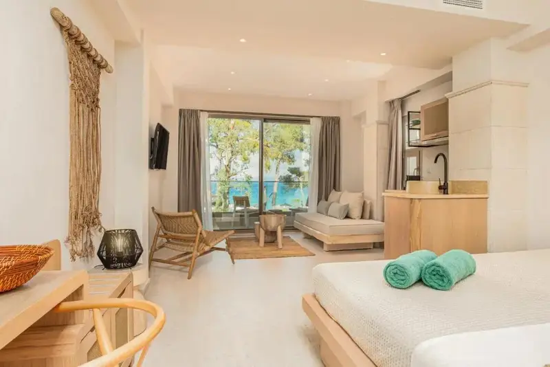 Espace de vie lumineux avec coin salon et kitchenette donnant sur une vue mer.